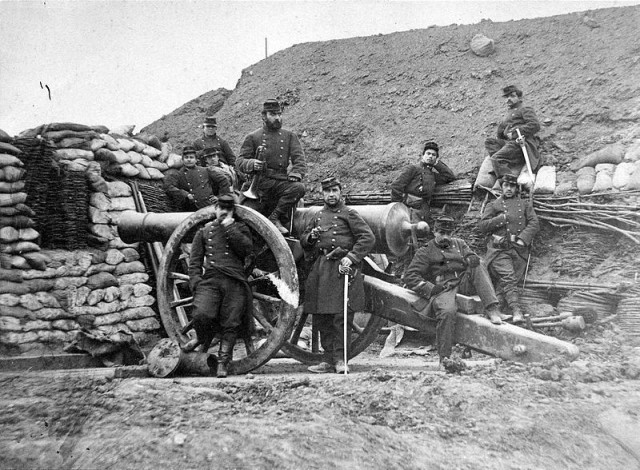 French soldiers with muzzle-loading cannon in the Franco-Prussian war (note rammers in the background for priming the weapon) 