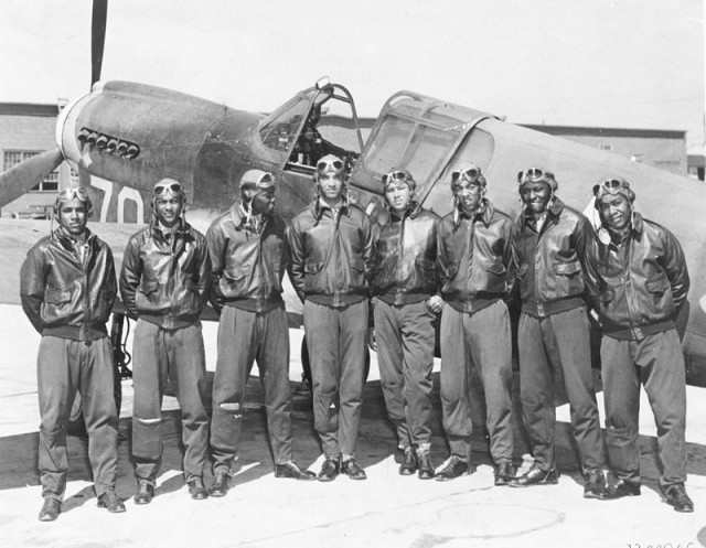 Eight Tuskegee Airmen in front of a P-40 fighter aircraft. By The original uploader was Signaleer at English Wikipedia - http://www.af.mil/shared/media/photodb/photos/020903-o-9999b-098.jpgTransferred from en.wikipedia to Commons., Public Domain.