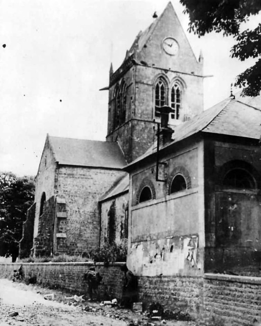 82nd Airborne Troops by church in Sainte-Mère-Église Normandy. The same church where John Steele was caught on the spire (Image).