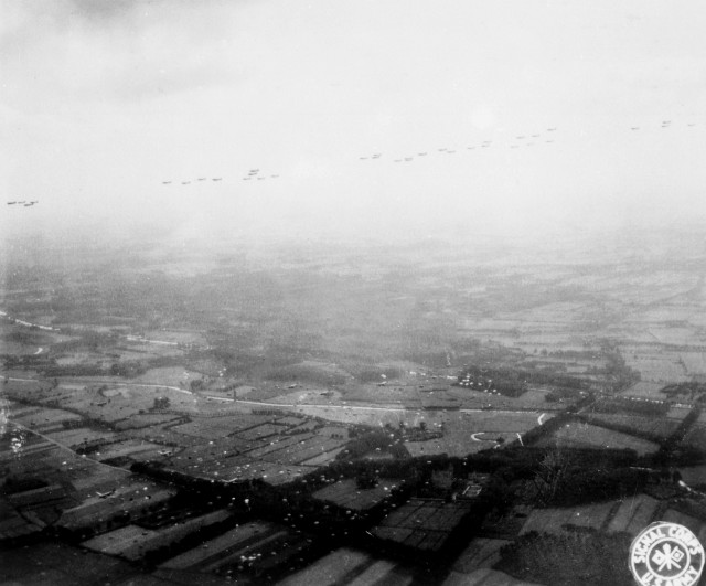 A fleet of Allied aircraft flies overhead as paratroopers of the Allied Airborne Command float groundward in the invasion of the Netherlands, still another step towards the liberation of Europe.