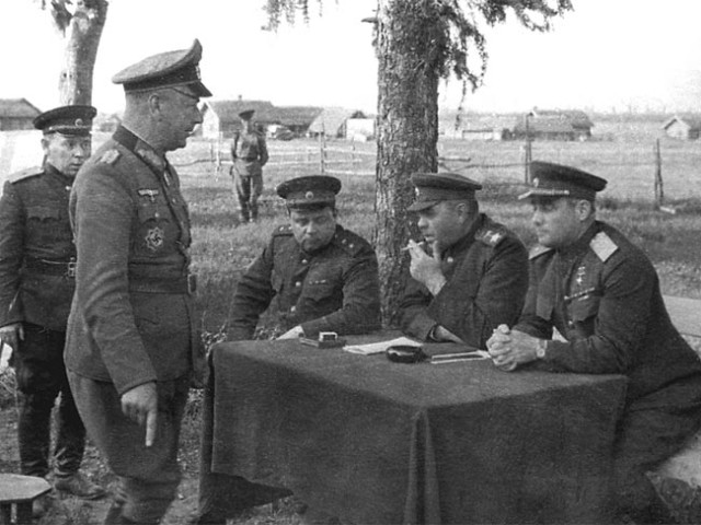 Generalleutnant Alfons Hitter, standing, is publicly interrogated by General Ivan Chernyakhovsky and Marshal of the Soviet Union Aleksandr Vasilevsky after the battle of Vitebsk [via]