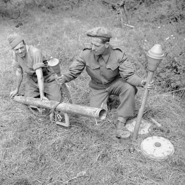 Instructors at a 59th Division school for potential NCOs at Vienne-en-Bessin demonstrate various German anti-tank weapons, including a Panzerschreck, two types of Panzerfaust and anti-tank mines, 1 August 1944 (© IWM (B 8540))