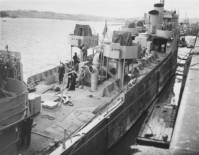 HMS Campbeltown being converted for the raid. There are twin lines of armour plate down each side of the ship and the Oerlikon mountings. Two of her funnels have been removed, with the remaining two cut at an angle.