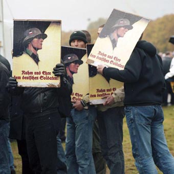 Germans protesting the exhibit in Munich on 12 October 2002 by holding up glorified posters of the Wehrmacht