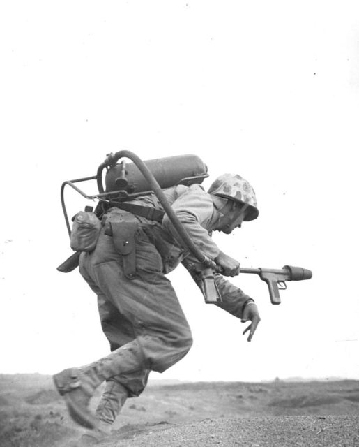 A flamethrower operator of Co. E, 2nd Bn, 9th Marines, runs under fire on Iwo Jima, February 1945 [ Official U.S. Marine Corps Photograph 111006].