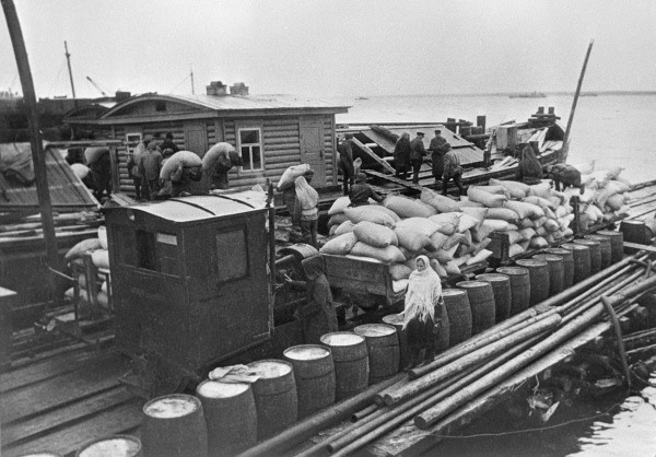 Supplies being unloaded from a barge on Lake Ladoga to a narrow-gauge train in 1942 [RIA Novosti archive, image #310 / Boris Kudoyarov / CC-BY-SA 3.0]