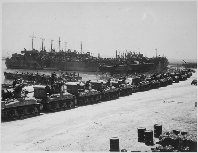 L.S.T's lined up and waiting for tanks to come aboard. Two days before invasion of Sicily. [U.S. National Archives and Records Administration]