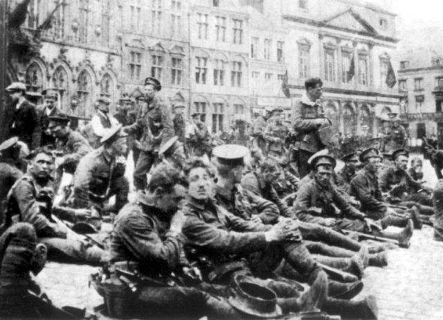 "A" Company of the 4th Battalion, Royal Fusiliers (City of London Regiment), part of 9th Brigade of 3rd Division, resting in the town square at Mons before entering the line prior to the Battle of Mons. Public Domain, https://commons.wikimedia.org/w/index.php?curid=91487
