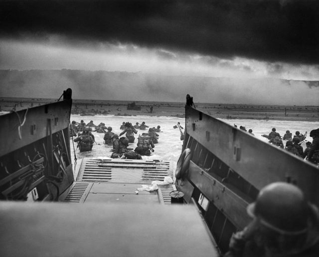 A LCVP (Landing Craft, Vehicle, Personnel) from the U.S. Coast Guard-manned USS Samuel Chase disembarks troops of Company E, 16th Infantry, 1st Infantry Division (the Big Red One) wading onto the Fox Green section of Omaha Beach (Calvados, Basse-Normandie, France) on the morning of June 6, 1944. Wikipedia / Public Domain