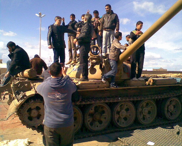 Civilians atop a T-55 tank in Libya, 2011; Photo Credit