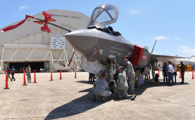 Airmen gather around an F-35 on a landing strip