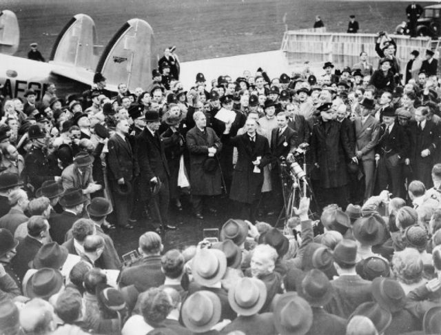 Neville Chamberlain, the Prime Minister, makes a brief speech announcing "Peace in our Time" on his arrival at Heston Airport after his meeting with Hitler at Munich, 30 September 1938 (© IWM (D 2239) / Wikipedia / Public Domain)