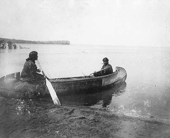 Pair of Native Americans in a canoe (Wikipedia / Public Domain)