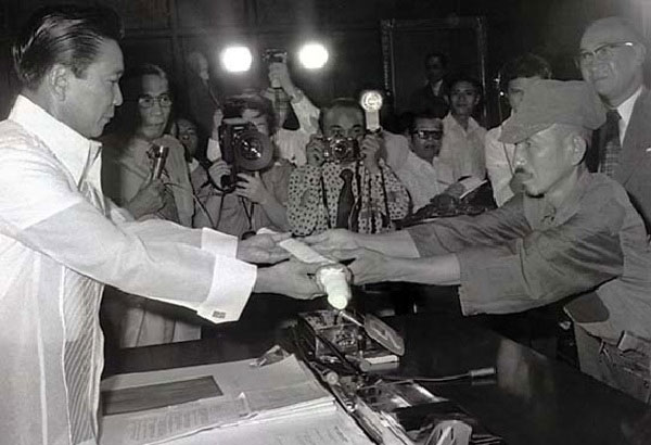 Japanese imperial army soldier Hiroo Onoda (right) offering his military sword to Philippine President Ferdinand E. Marcos (left) on the day of his surrender, March 11, 1974.
