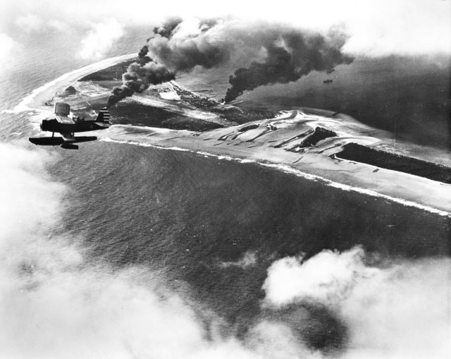 A U.S. Navy SOC Seagull floatplane flies over Wotje Atoll, during the attack on the Japanese airfield there by gunfire from USS Salt Lake City (CA-25) and USS Northampton (CA-26) and fighters from USS Enterprise (CV-6), 1 February 1942.