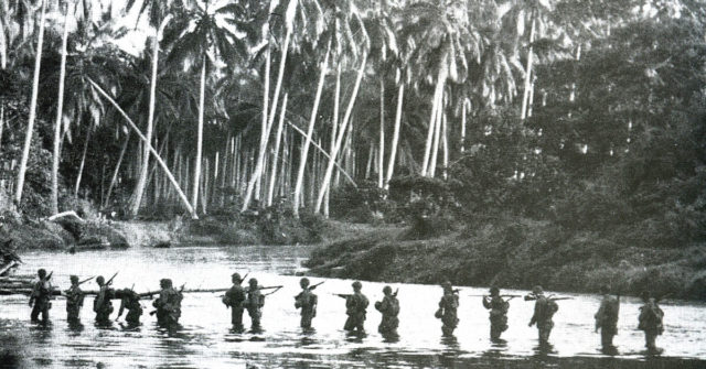 A U.S. Marine patrol crosses the Matanikau River, Guadalcanal, Solomon Islands, in September 1942.