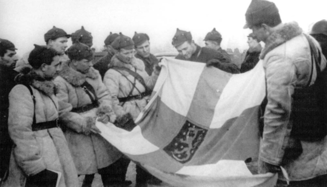 Red Army soldiers display a captured Finnish state flag.