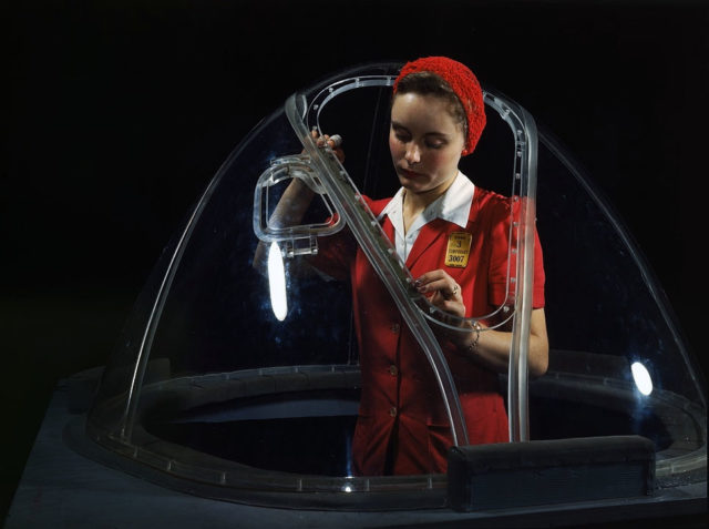 1938. Woman in a glass house is putting finishing touches on the bombardier nose section of a B-17F navy bomber, Long Beach, Calif.