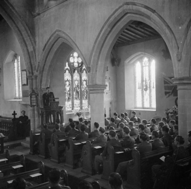 Thanksgiving Day Service Held in English Country Church- Americans in Cransley, Northamptonshire, England, UK, 23 November 1944 Men of the US Army Air Corps listen to a sermon on 'The Source of our Strength' during a Thanksgiving service at Cransley in Northamptonshire. The sermon is being given by Chaplain Ward J Fellows. Just visible to the left of the pulpit is Reverend Greville-Cooke, the vicar of Cransley.