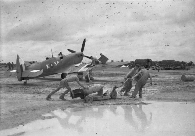 Airmen prepare a Supermarine Spitfire Mark VIII for a sortie during moonsoon conditions at Mingaladon, Burma.
