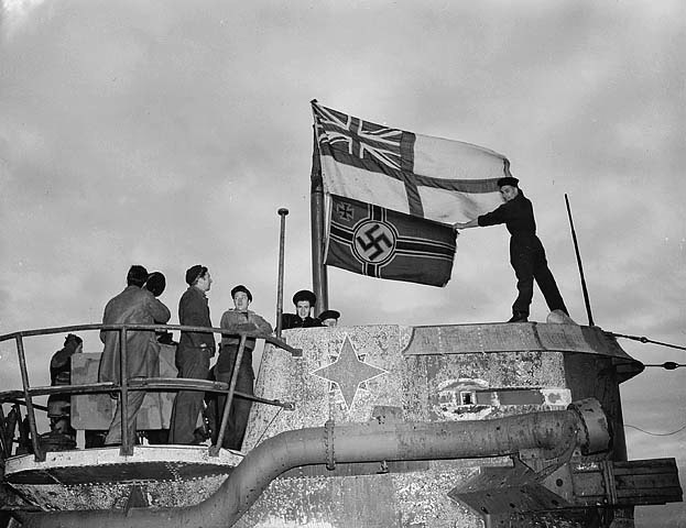 Seamen raise the White Ensign over a captured German U-boat in World War II.