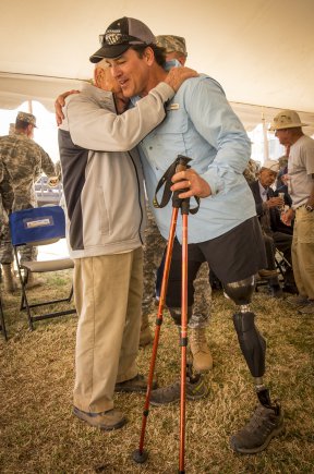 Former Navy Special Operations Master Chief Harold Bologna, a double amputee, embraces retired U.S. Army Col. and Bataan Death March Survivor Ben Skardon after they each walked more than eight miles in the Bataan Memorial Death March at White Sands Missile Range, N.M., March 20, 2016. Credit: U.S. Army photo by Staff Sgt. Ken Scar.
