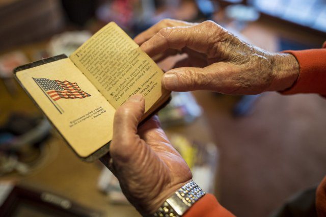 Former U.S. Army 1st Lt. William H. Funchess, 89, reads from a Bible he kept throughout his 34 months as a prisoner of war during the Korean War, Sept. 21, 2016. Funchess was held in the same prison compound as Army Chaplain Father Emil J. Kapaun, who received the Medal of Honor posthumously in 2013 for his acts of courage and compassion as a prisoner of war. Funchess and Kapaun read from this Bible together on many occasions before Kapaun succumbed to starvation and disease. Credit: U.S. Army photo by Staff Sgt. Ken Scar.