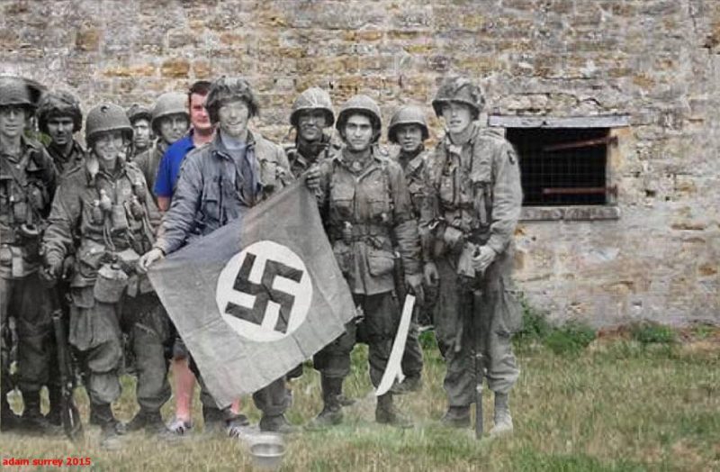 Posing with a captured German flag,Marmion Farm, Ravenoville,Normandy. 1944 – 2015 (now photo Roel van Regteren ty) / By Adam Surrey / Ghosts of Time