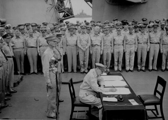 Lt. Gen Wainwright witnessing the Japanese surrender behind Gen. MacArthur