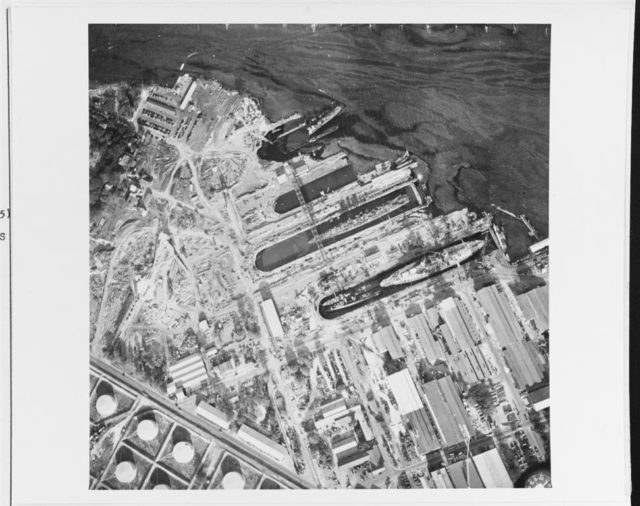 Aerial photo of Pearl Harbor Naval Shipyard taken 10 December 1941 showing the intact dry docks (center), repair shops (lower right) and a portion of the oil storage facilities (lower left) – Naval History & Heritage Command