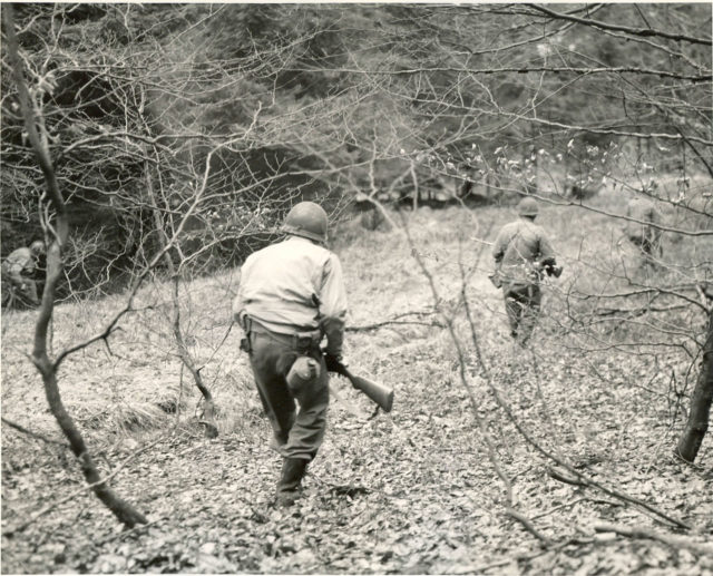 A patrol of Company F, 3rd Battalion, 18th Infantry Regiment, 1st Infantry Division, searches the woods between Eupen and Butgenbach, Belgium, for German parachutists.