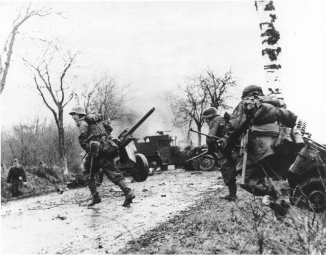 German soldiers advance during the Battle of the Bulge. By Bundesarchiv – CC-BY SA 3.0