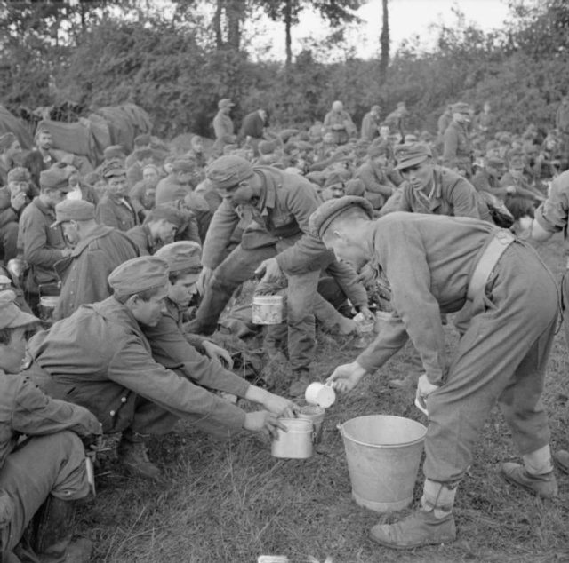 German prisoners being given tea by British troops after the defeated German counterattack at Falaise Pocket, August 22 1944.