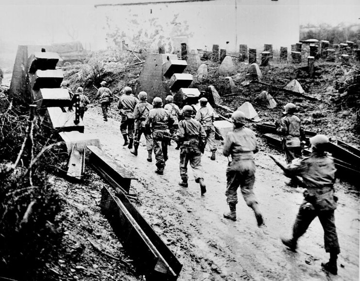 American soldiers cross the Siegfried Line and march into Germany.