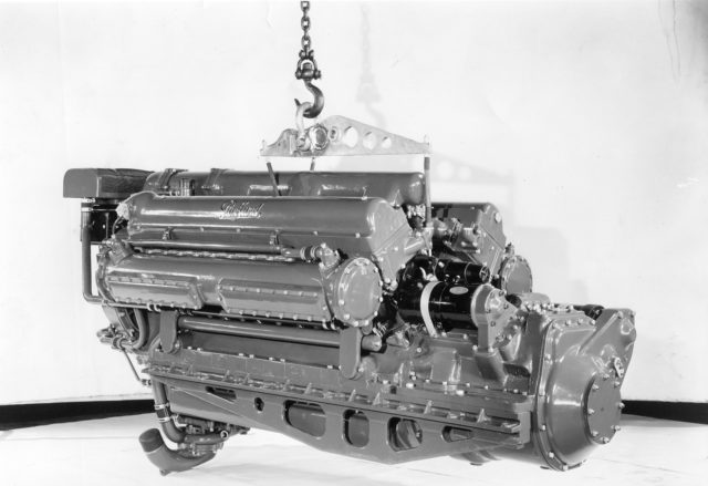 Photo shows the Packard V-12 4M-2500 engine, of which each PT-boat had three of them. A very reliable and powerful engine that was developed from the Liberty aero-engine, which came out in the late 1920’s in its first variant. It is a V-12 -12 cylinders 4 -stroke Marine petrol engine, Model W7/W8, Weight is some 3,000 lbs. Supercharged, 2490 cu in. displacement, 48 valves (4 per cylinder) and double spark plugs, 2400 RPM cruising, 3000 RPM max revs. Rated at 1,500 BHP, which was a fair output when related to the radial engines Pratt & Whitney R-1830 Twin Wasp (the engine that propelled the Dc-3/C-47, the PBY Catalina/ Canso and B-24) that cranked out 1,200 BHP from 1830 cu in. with similar RPM. Both engine types were true ” Rulers of Reliability” and that counts for sneaking prowlers on the hunt