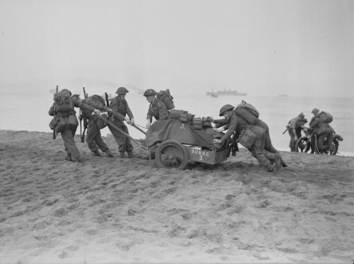 Soldiers dragging equipment ashore.