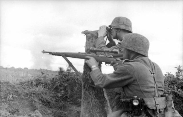 German sniper aiming his Karabiner 98k with 4x Zeiss ZF42 telescopic sight. By Bundesarchiv – CC BY-SA 3.0 de