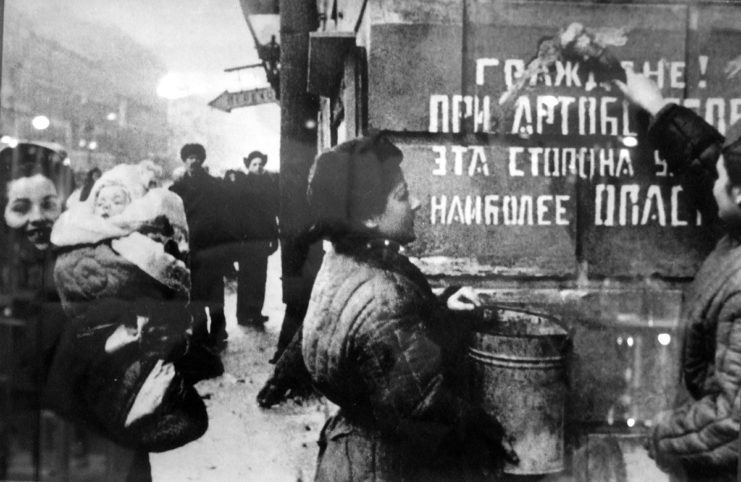 The exultant Leningrad. Sign on the wall says: Citizens! This side of the street is the most dangerous during the artillery barrage.