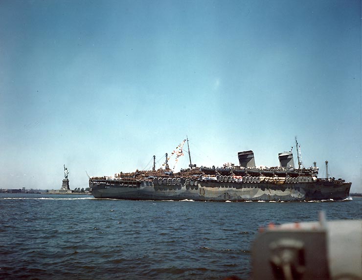The U.S. Navy troop transport USS West Point (AP-23) steams past the Statue of Liberty, bound for the New York City docks, while transporting troops home from Europe, 11 July 1945.