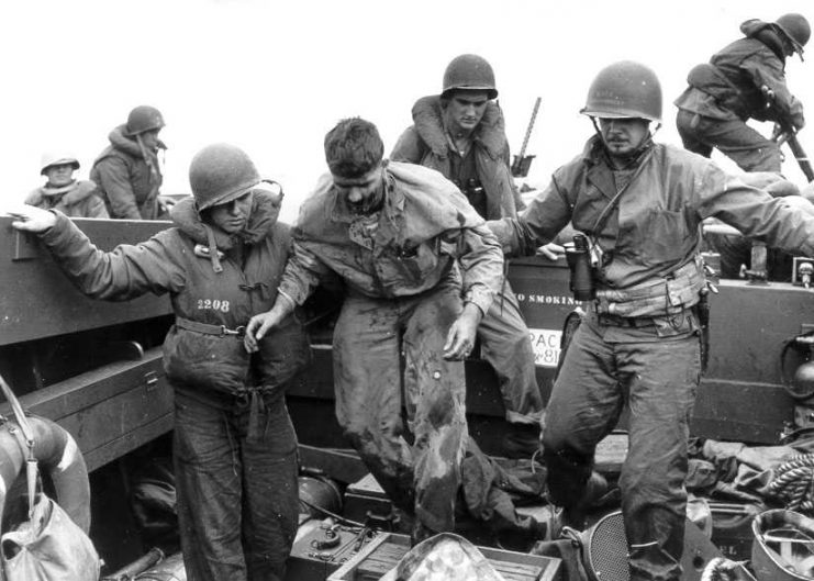 Wounded US Marines moved by the US Coast Guard sailors on landing craft on Iwo Jima