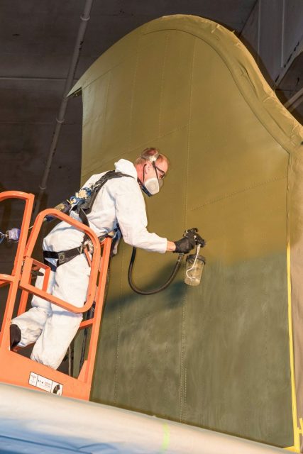 Another shot showing the restoration team painting the olive drab topcoat on Memphis Belle’s fin. (U.S. Air Force photo by Ken LaRock)