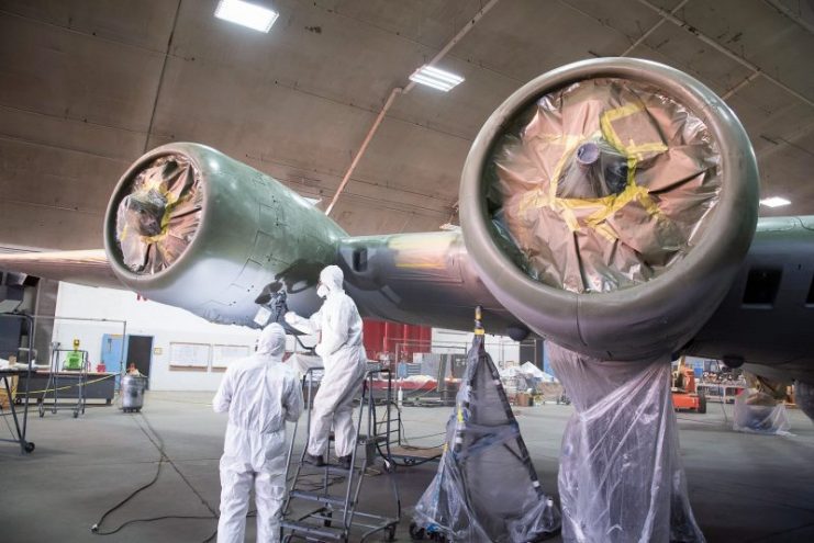 Painting the gray coat on the under side of Memphis Belle’s No.4 engine. (U.S. Air Force photo by Ken LaRock)