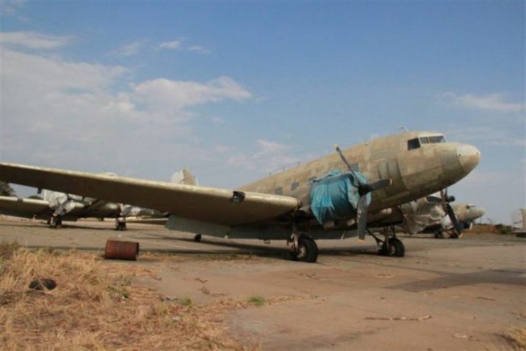 Photo above: Latest information from Brian is that he also did acquire the five C-47s in Zimbabwe from their Air Force and bought all of their spare parts and engines. The airframes were transferred by road to Wonderboom Airport in July/August 2017 and are now in Johannesburg waiting for their next step. Some years ago, I saw them coming for sale in an auction, I was interested in parts but the auction never took place. At least, it seems that they are now saved from the scrapper! However, with five DC-3s that came for sale in Madagascar, it all went completely awry. For a long time, I negotiated with the Military out there. All in vain, one day I got a telephone call that all Dakotas were being scrapped and sold as aluminum ingots for the local production of domestic devices as pots and pans! (For more details and photos of that horrible mishap in Madagascar, see my book The Dakota Hunter, chapter 7, ‘Dancing with Colonels’).Here follow the ZIM DAK C/ N numbers, all info via Brian and Michael Prophet, my good friend and DC-3 Photographer/ informer:Air Force of Zimbabwe 5 x C-47s: reg nr. 3700-C/N 13164, reg nr 7036-C/N 14494/25939, reg. nr 7053- C/N 16011/32759, reg nr 7301- C/N 16335/33083, reg nr. 7303-C/N 13867/25312.