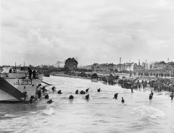 Follow-up waves of the 9th Canadian Infantry Brigade disembarking with bicycles from landing craft onto ‘Nan White’ sector of Juno Beach at Bernieres-sur-Mer, 6 June 1944.