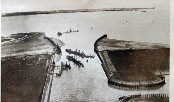 A panorama of Zeebrugge harbor soon after the St. George’s Day raid. HMS Thetis lies about half a mile out of position in the background, with HMS Iphigenia and HMS Intrepid parallel to each other in the canal mouth itself.