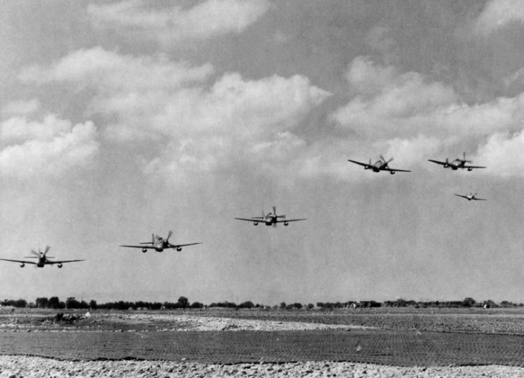 U.S. Army Air Forces North American P-51C Mustang fighters of the 332nd Fighter Group take off from Ramitelli airfield, Italy, to escort heavy bombers sent to bomb a German refinery for synthetic oil at Blechhammer (today Blachownia Śląska, Poland), on 7 August 1944. Note the P-51s have wing tanks for the extra fuel needed for such long missions.