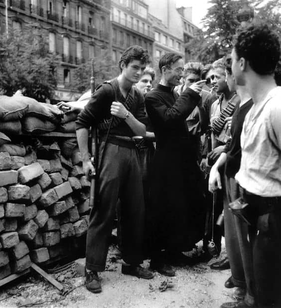 Father Camille Folliet, a French Roman Catholic priest, lends his support and advises the French Resistance behind a barricade during the Battle for Paris. D-Day was the spring board.