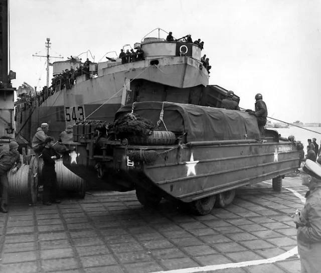 USS LST 543 is the first landing ship to unload at Loebnitz pier off Normandy, France in June 1944. The pier is a unit of the U.S. Mulberry, a man-made harbor.