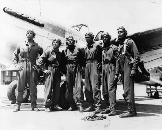 George Iles (third from left) with fellow Tuskegee Airmen and a Curtiss P-40 Warhawk.