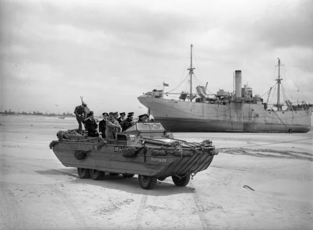 King George VI, accompanied by Admiral Sir Bertram Ramsay and the First Sea Lord, Admiral Sir Andrew Cunningham, touring the beaches at Normandy in a DUKW amphibious vehicle, 16 June 1944.